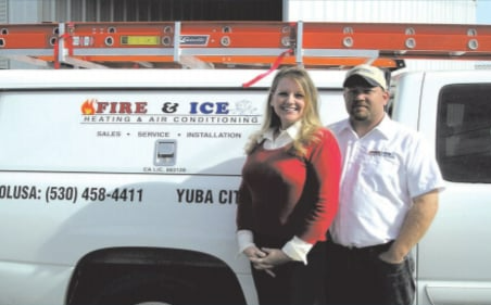 A man and woman standing in front of a fire and ice van