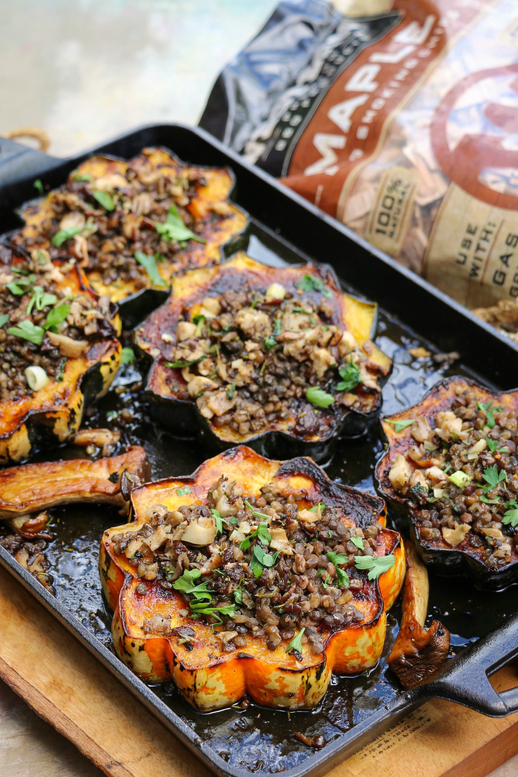 Grilled acorn squash topped with mushrooms and lentils next to a bag of Western Maple BBQ Smoking Chips
