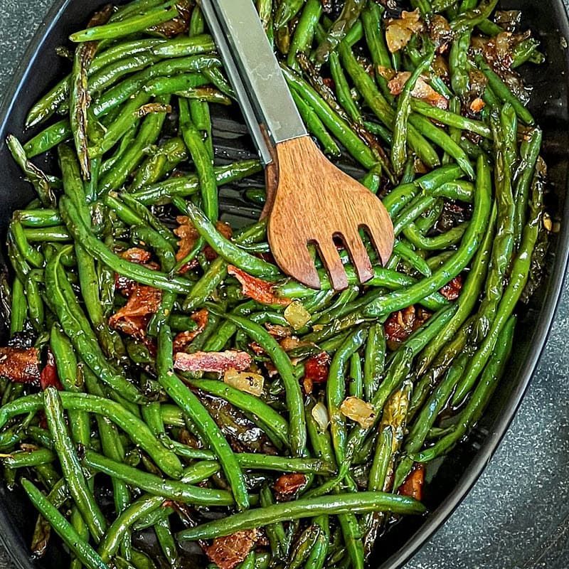 Maple Bacon Green Beans plated with serving utensils