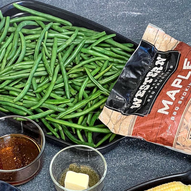 blanched green beans in a pan with butter, maple syrup and bag of Western Maple Smoking chips