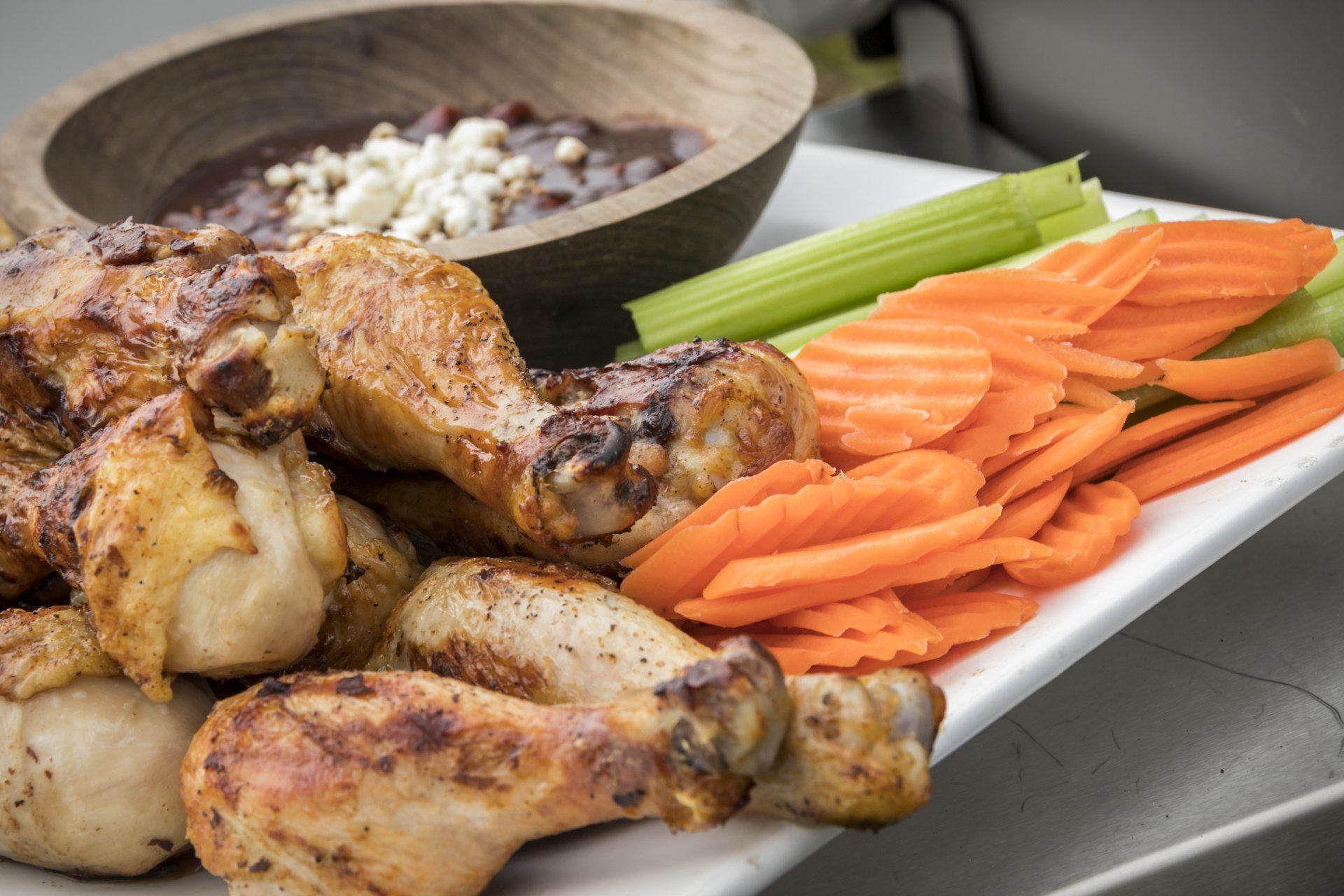 Jack Daniel’s Grilled Spicy Chicken Drumsticks with bowl of blue cheese dressing, carrots and celery