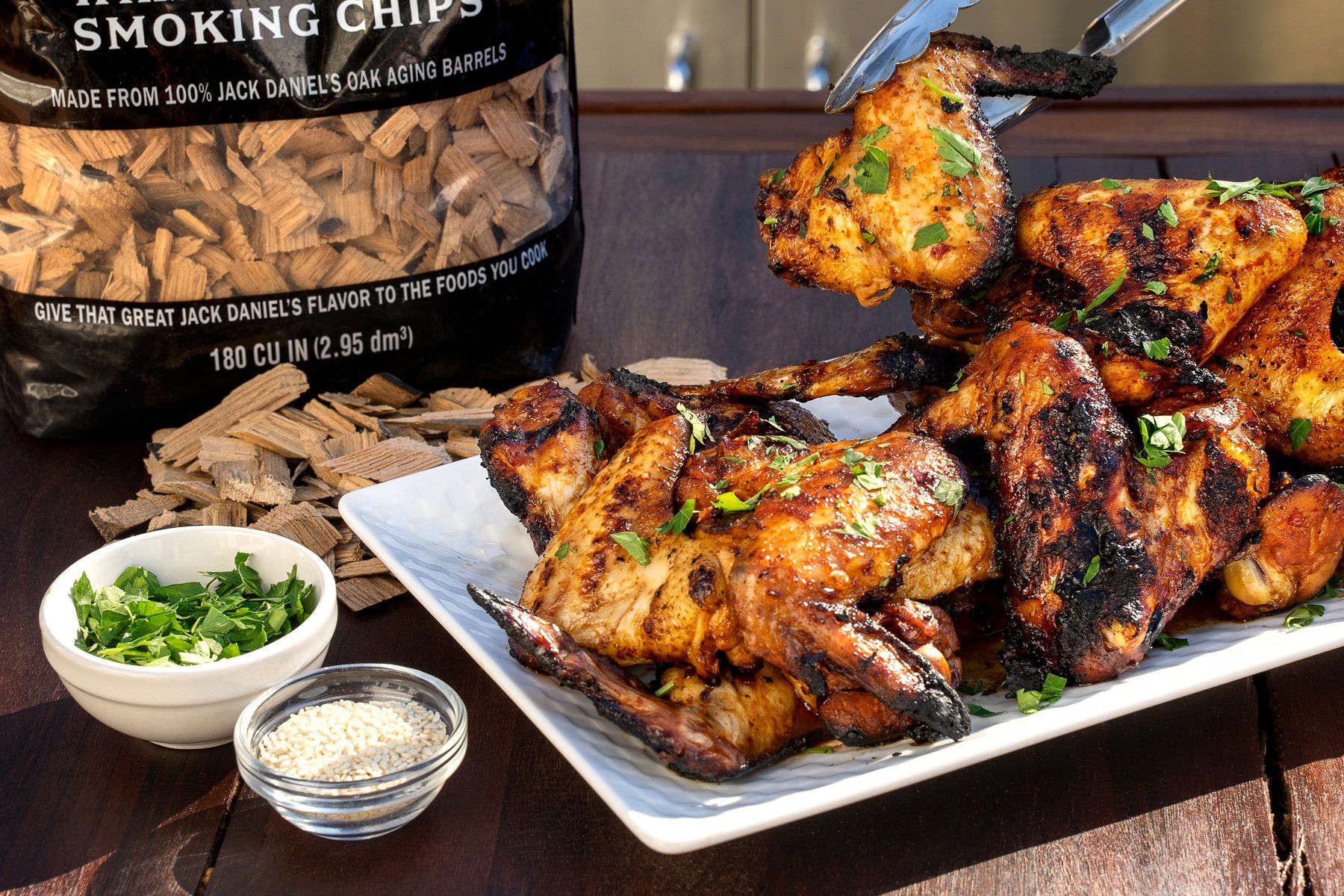 Grilled chicken wings on a platter with Jack Daniel's Whiskey Barrel Smoking Chips