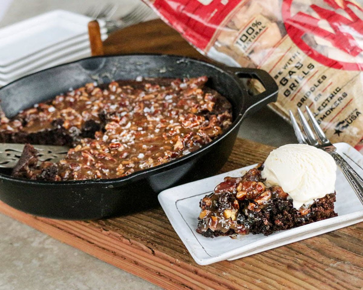 A skillet of brownie next to a plate of brownie with ice cream on it