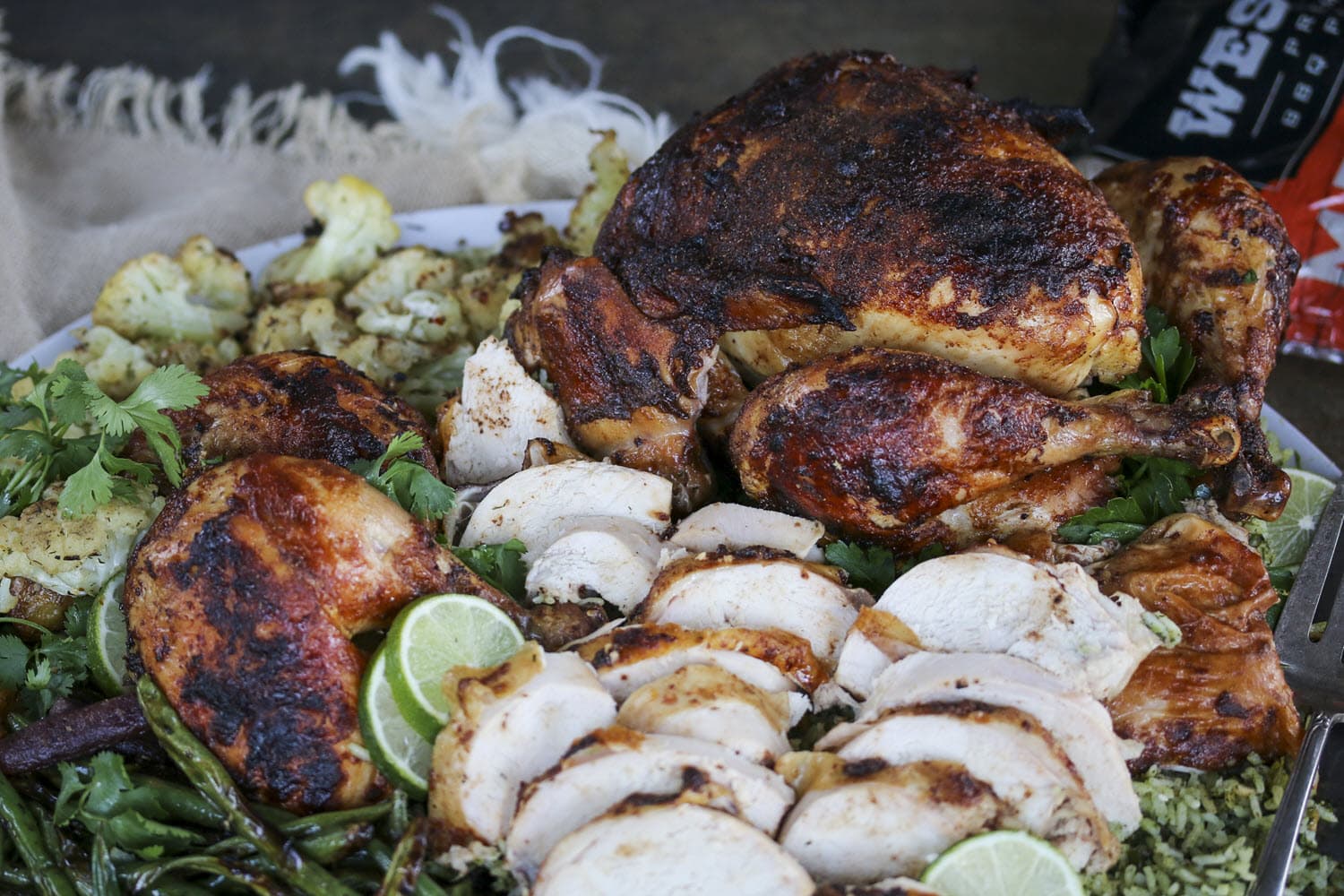Sliced and whole rotisserie chicken plated with vegetables