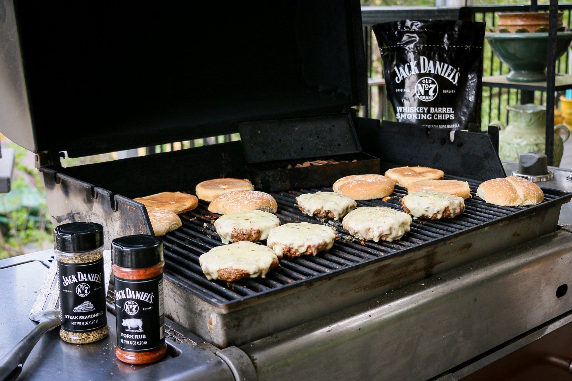 Pork Burgers with melted cheese & buns on grill with Jack Daniels Steak Seasoning, Pork Rub and Whiskey Barrel Smoking Chips bag