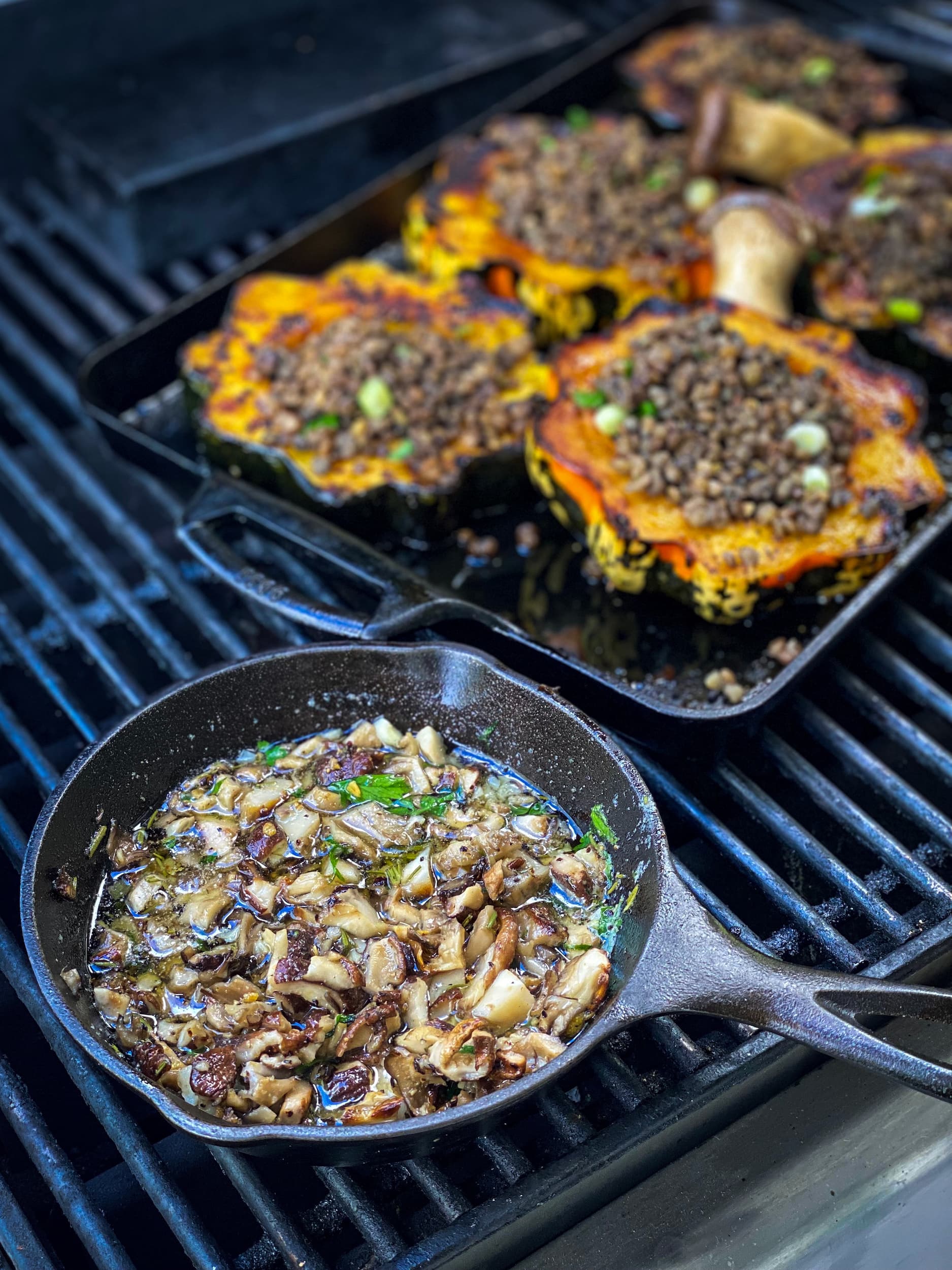 Mushroom lentils and acorn squash cooking in cast iron pans on grill