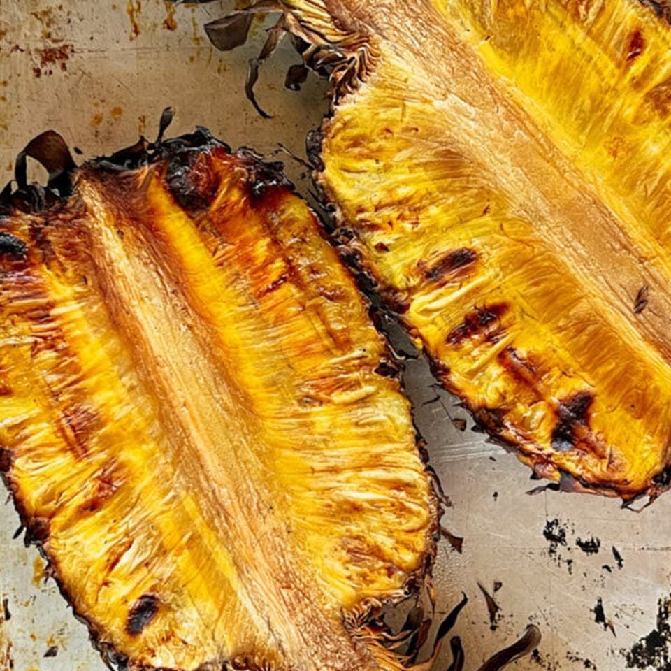 Pineapple halved and smoked with grill marks.