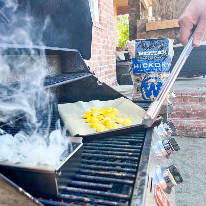 wood chips and egg yolks smoking on the grill with bag of Western Hickory Wood chips in background