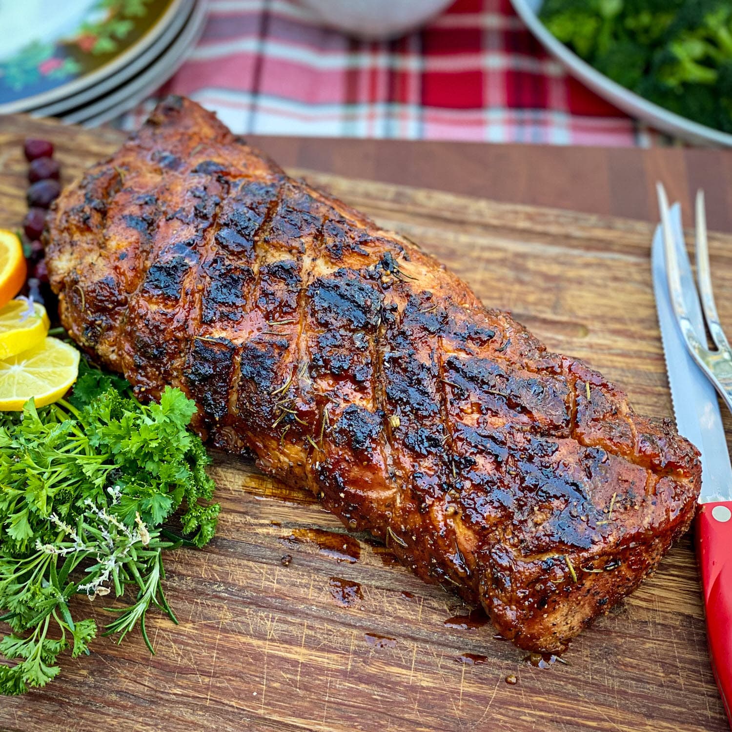 Cherry Smoked Pork Loin with glaze on cutting board with parsley