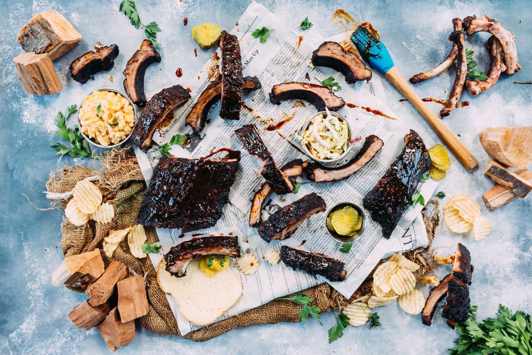 birds eye view of BBQ pork ribs with coleslaw potato chips pickles and mac and cheese
