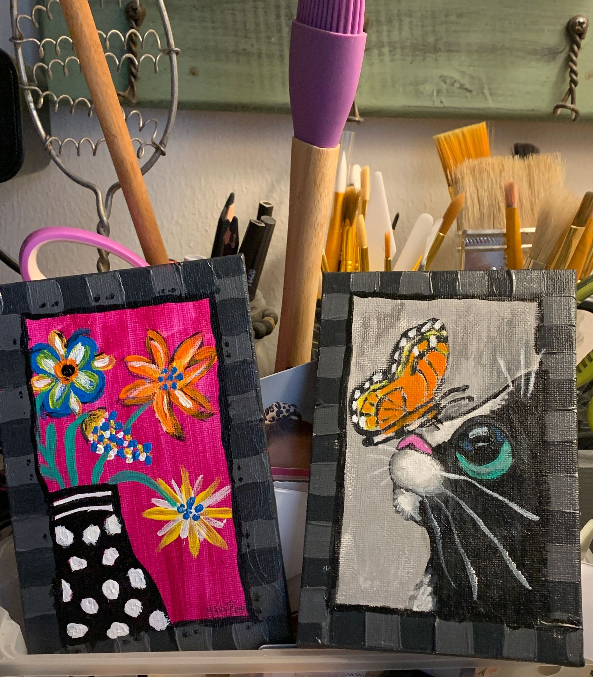 Two framed art pieces: flowers in a vase and a cat with butterfly.  By Mary Berry - Art