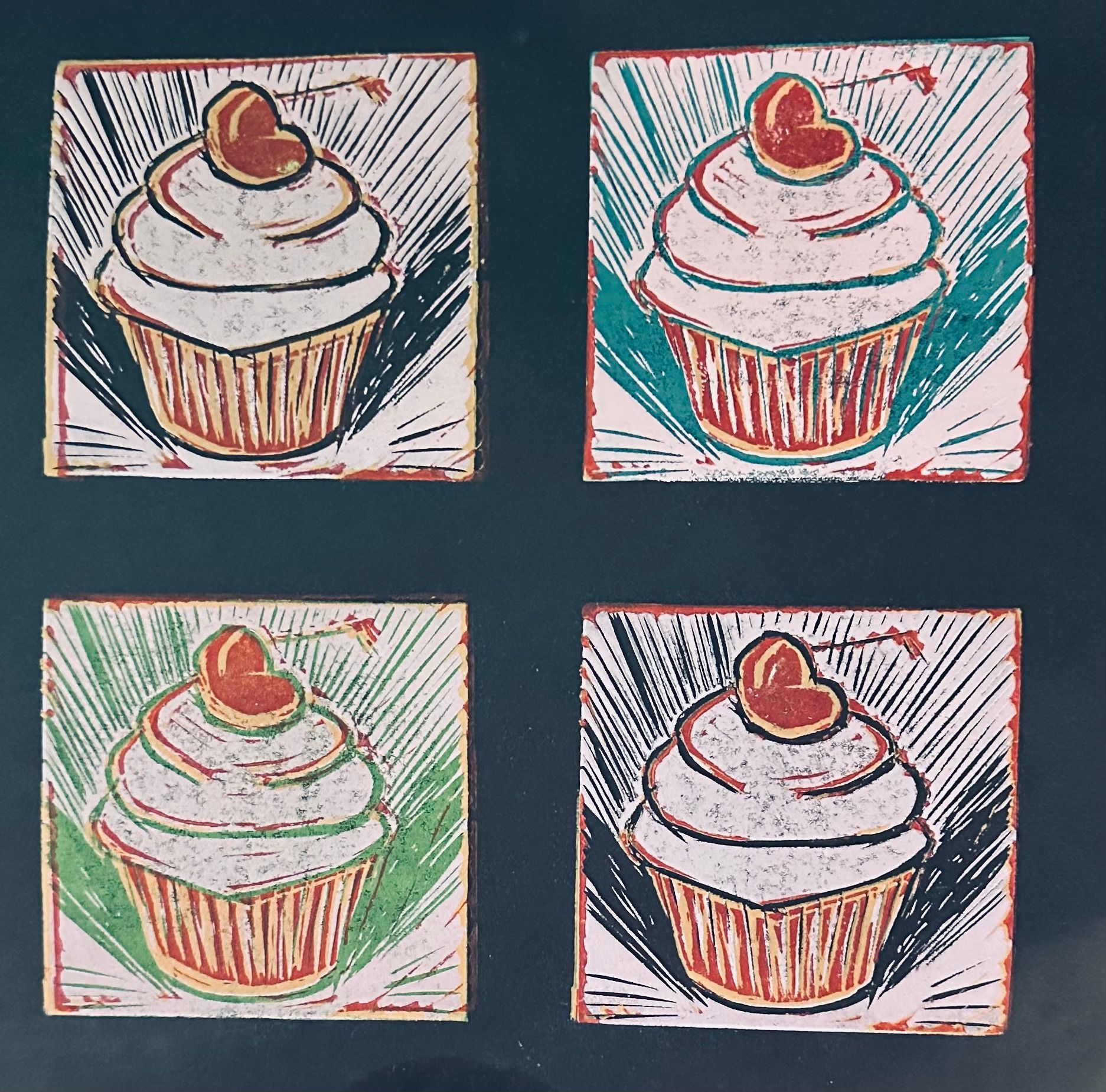 Four linocut prints of cupcakes with heart toppings in different color backgrounds.  By Mary Berry - Art