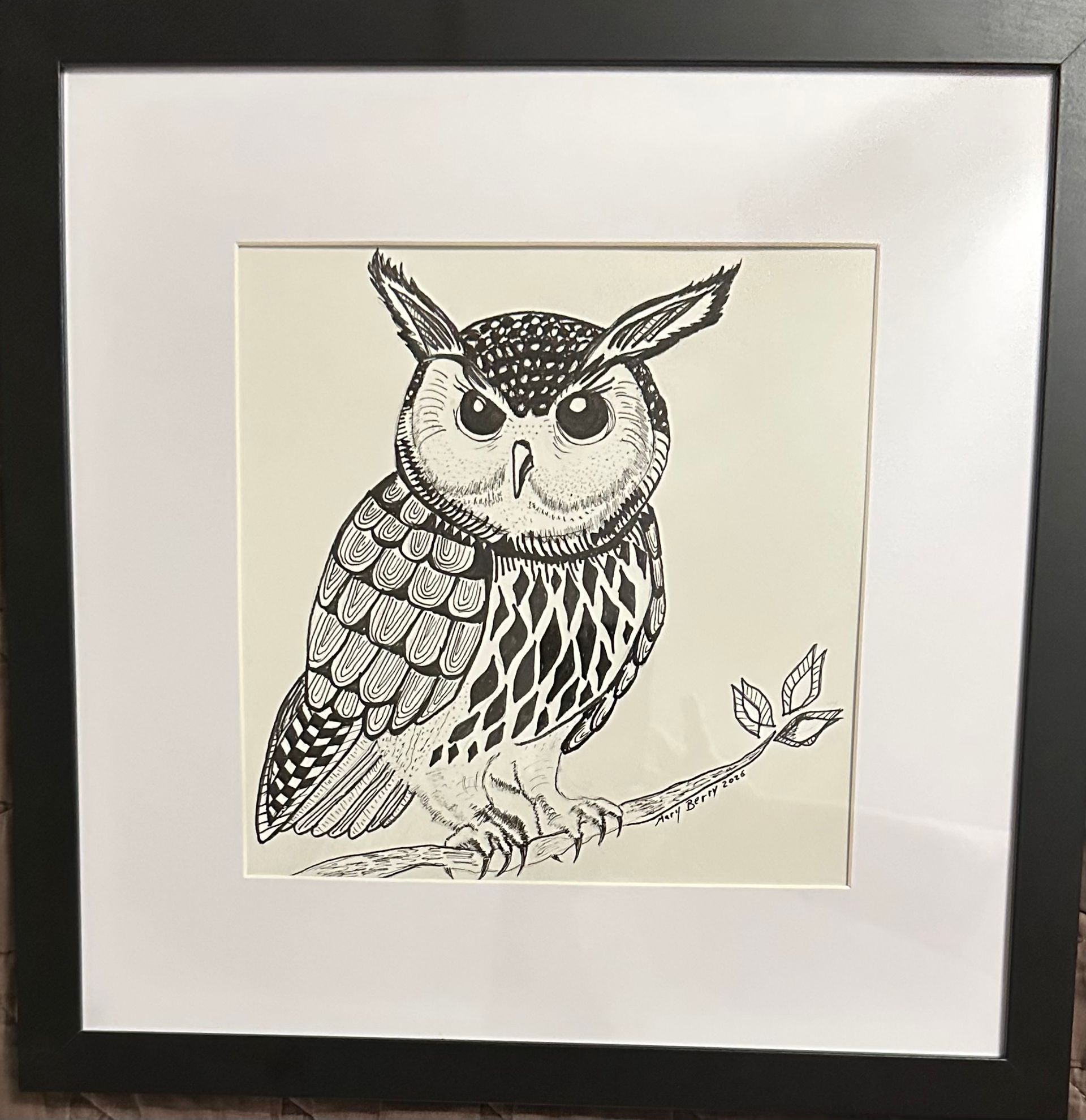 Black and white drawing of an owl perched on a branch, framed with a white mat and black frame.  By Mary Berry - Art