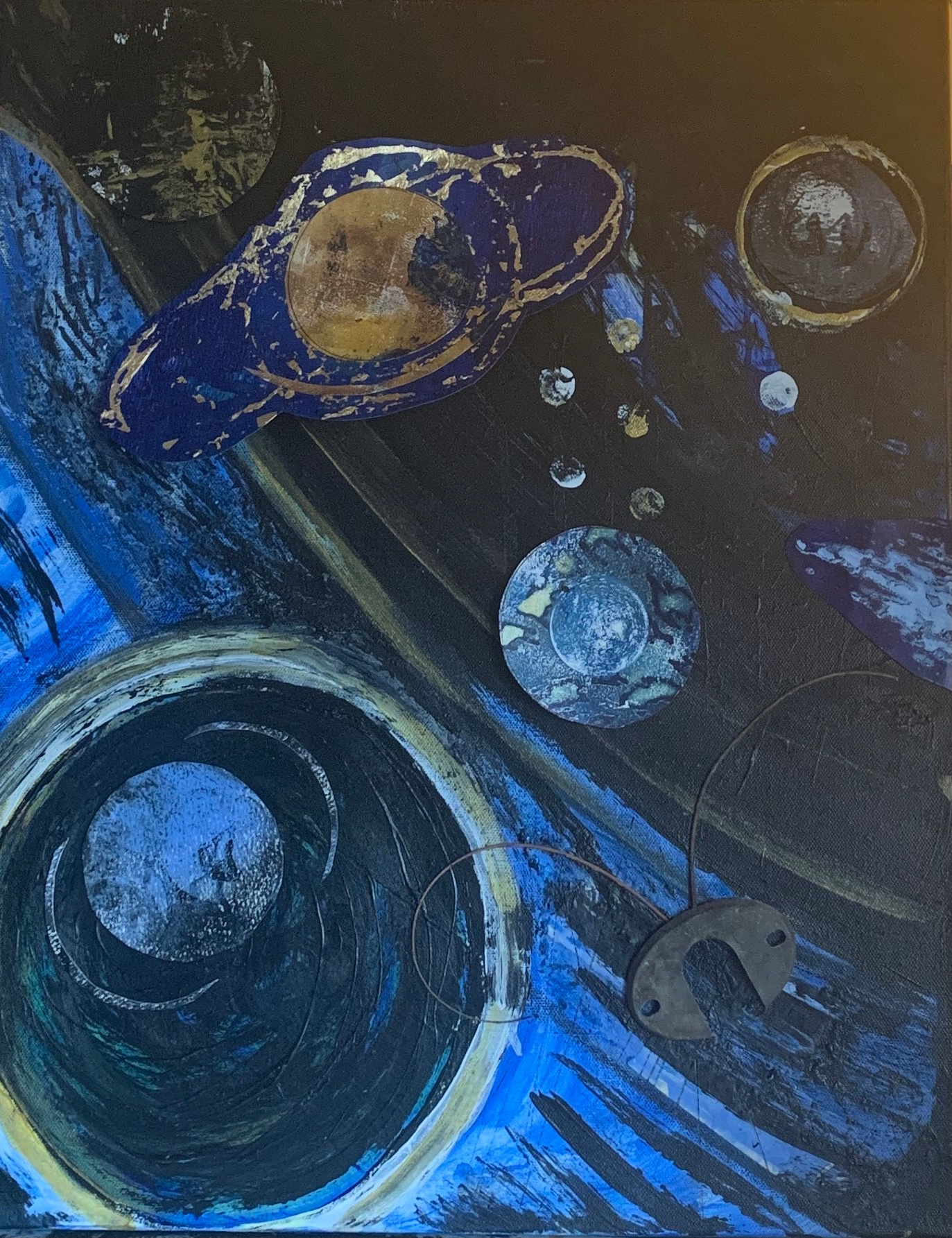 Abstract painting of planets in blue and gold on a dark background with swirling blue brushstrokes.  By Mary Berry - Art