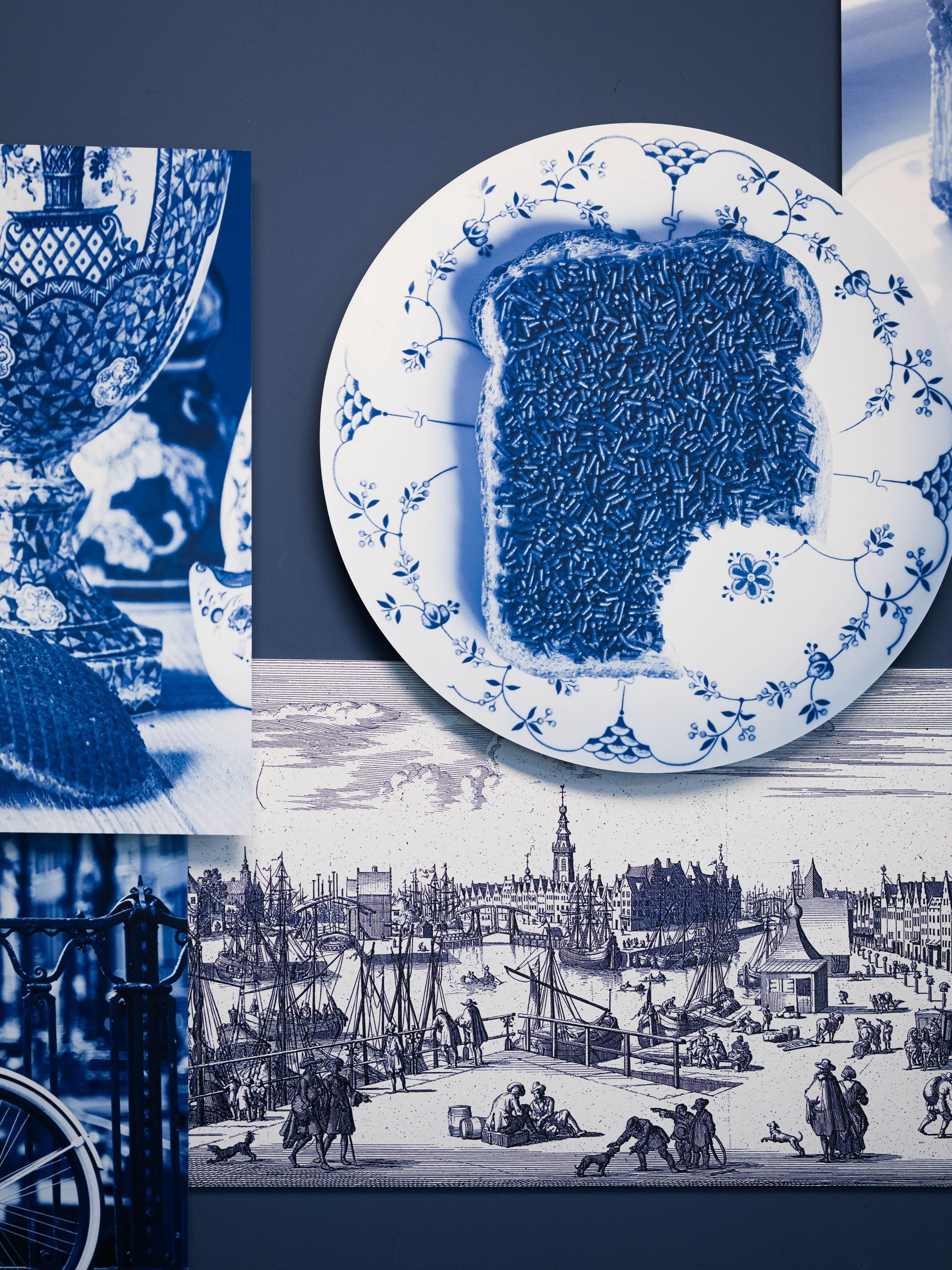 Blauw-wit bord met een donker ingevuld midden, omringd door andere afbeeldingen in Delfts blauw.