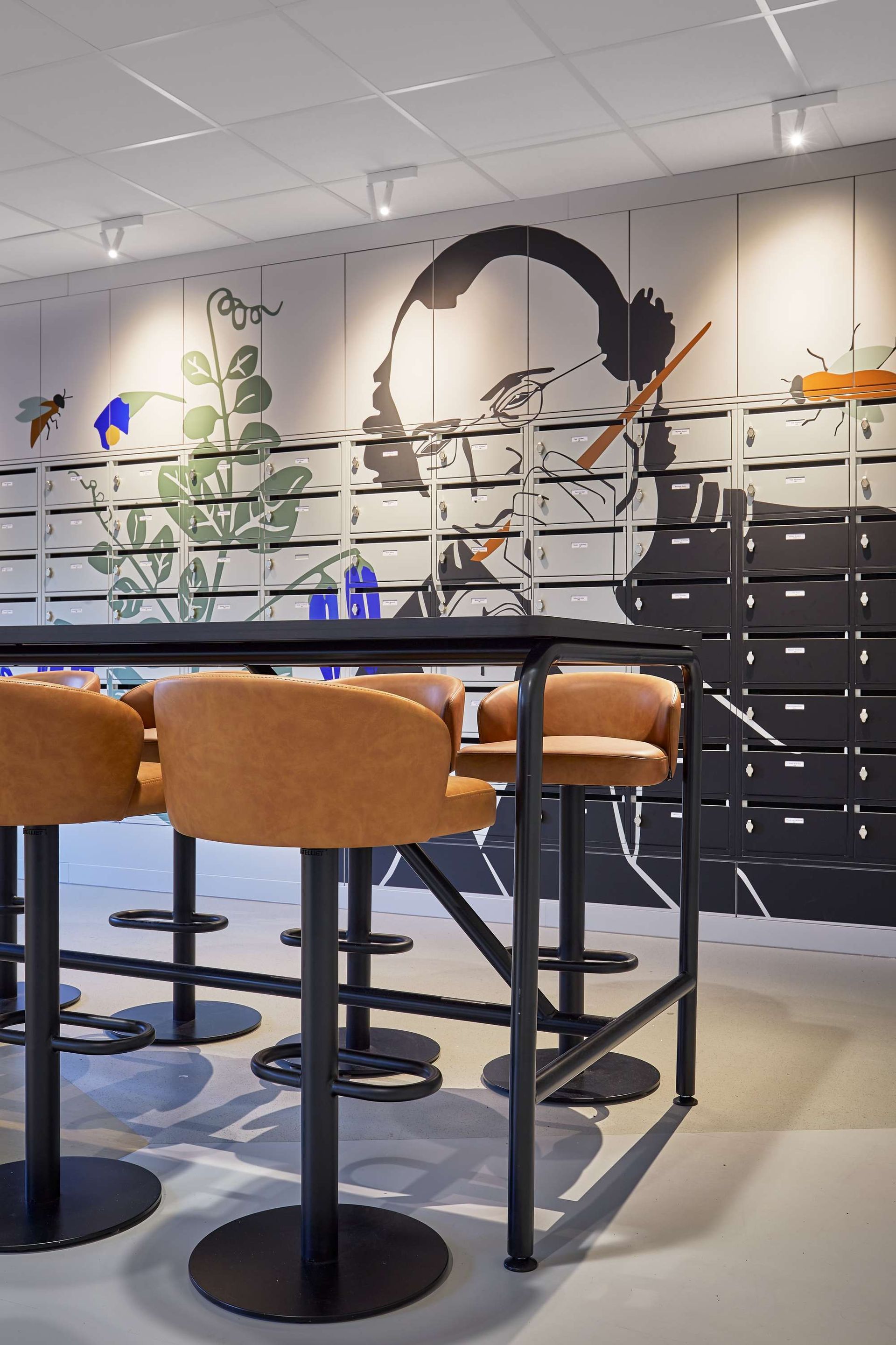 Een kamer met een tafel, stoelen en een muurschildering.