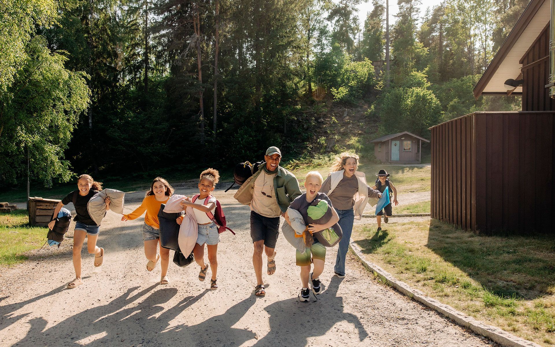 A group of children are running down a dirt road.