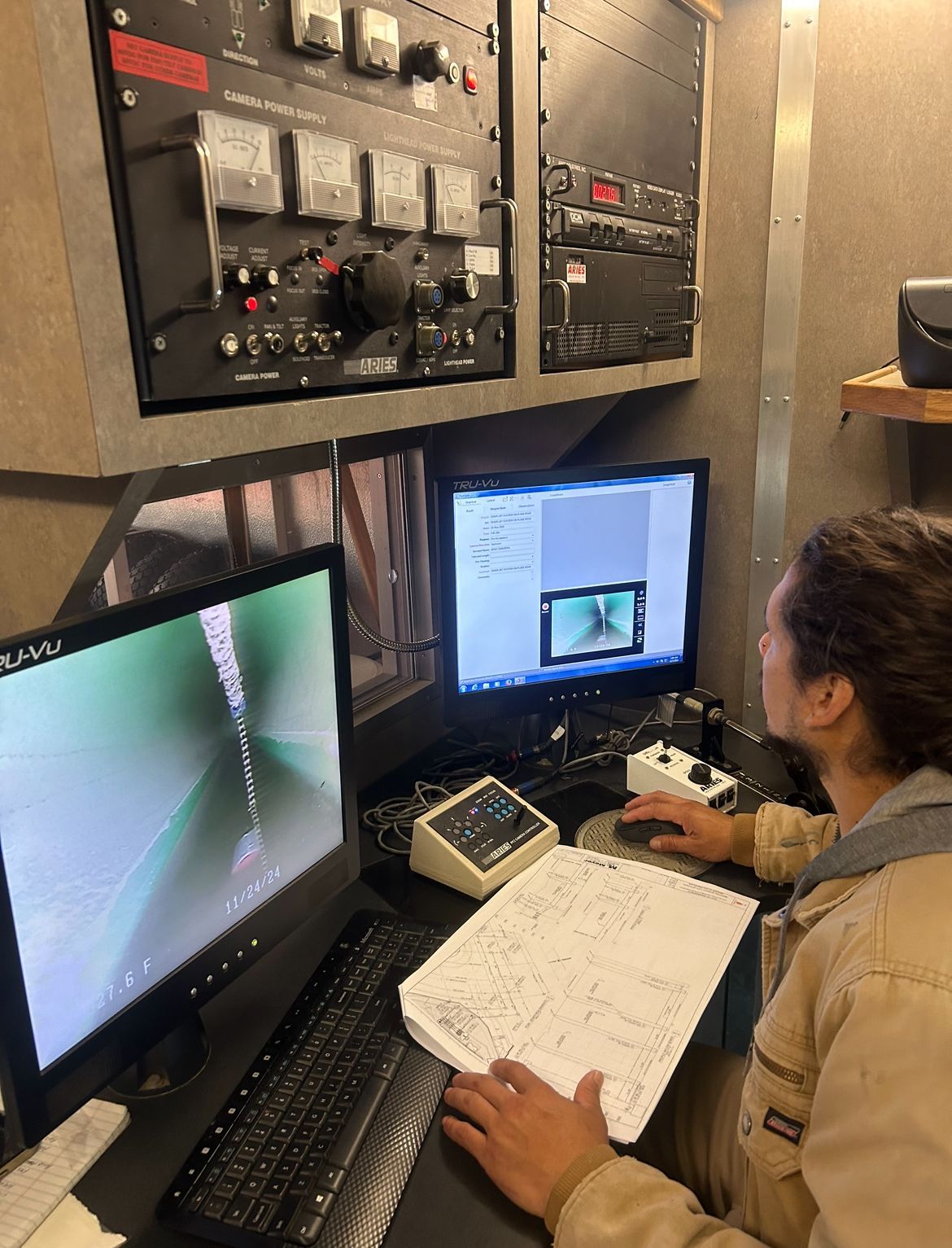 A man is sitting in front of a computer looking at a video inspection report.