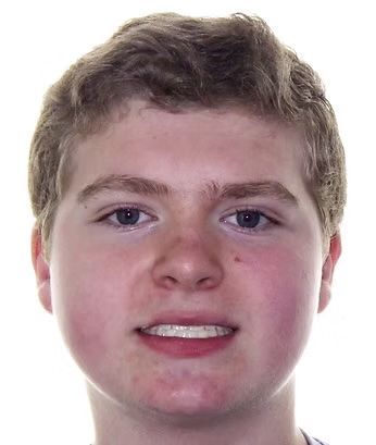 A light-skinned person with light brown hair smiles, showing teeth.