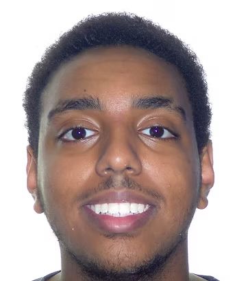 Smiling person with dark skin, short dark hair, and brown eyes.