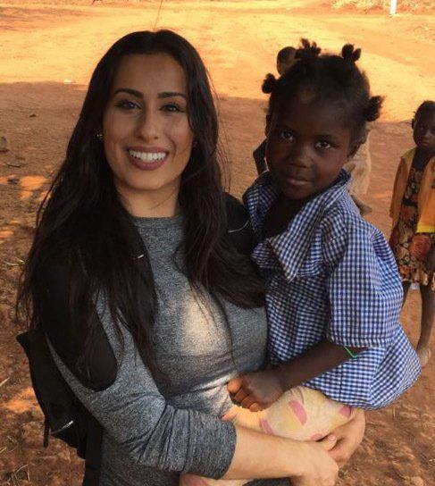 A woman is holding a little girl in her arms