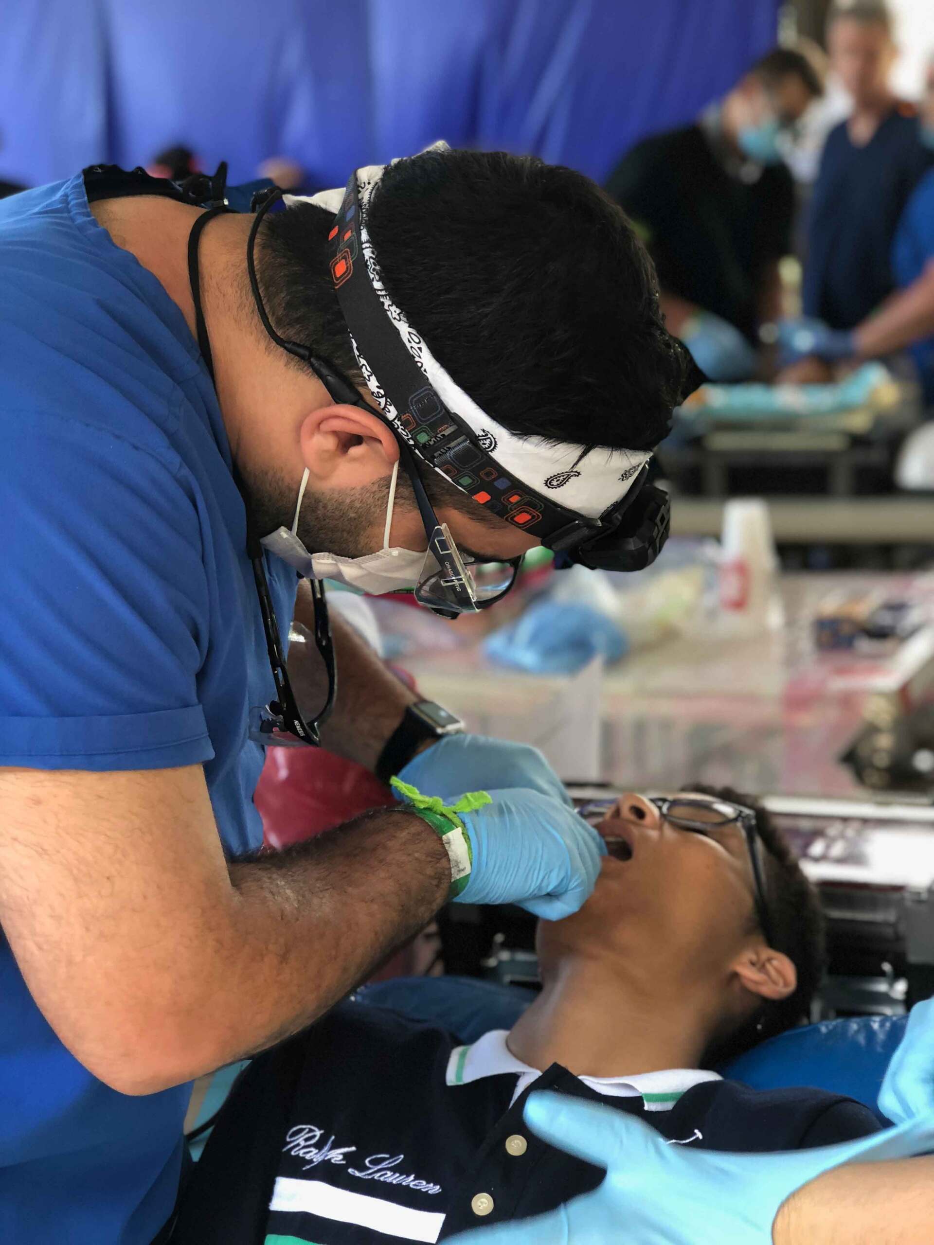 A dentist is working on a young boy 's teeth