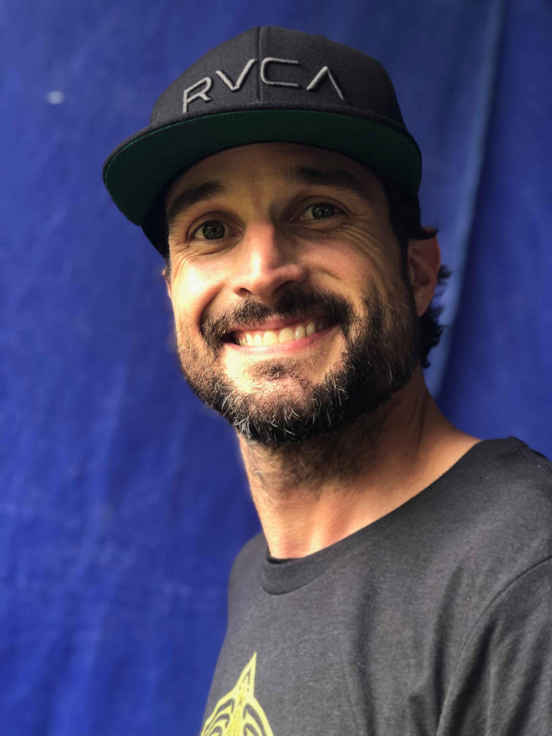 A man wearing a hat that says rvca on it