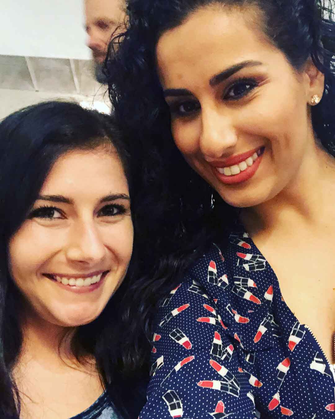 Two women are posing for a picture and smiling for the camera