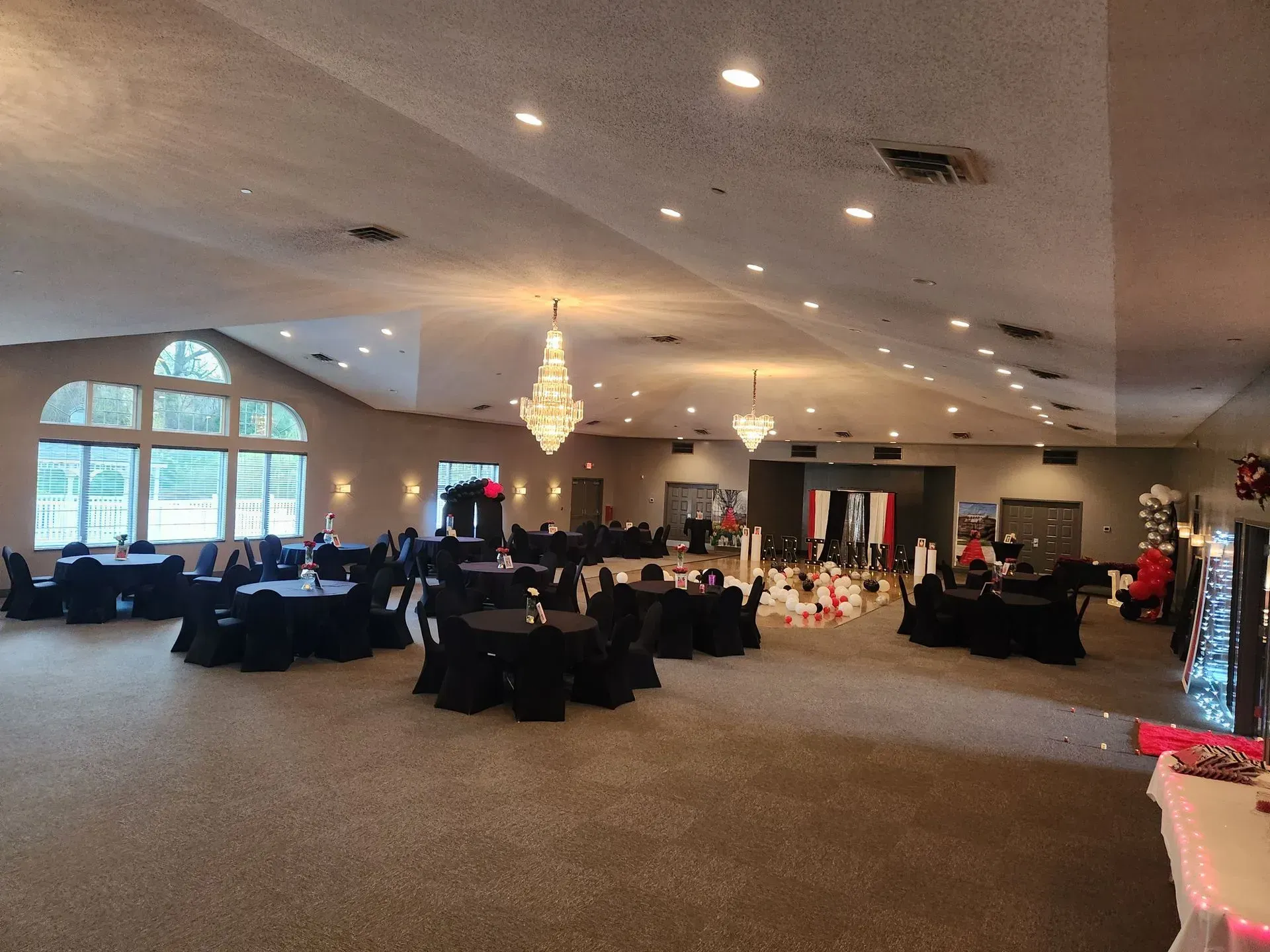 Large event space with round tables covered in black linens.