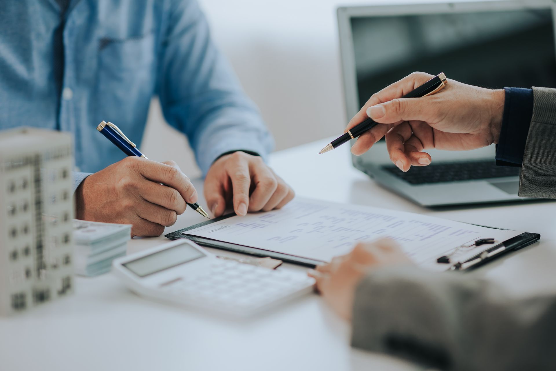 A man and a woman are sitting at a table signing a document.