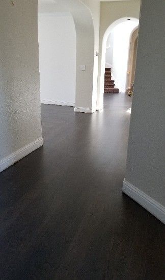 Interior view with hardwood floors, doorway, and beige walls.