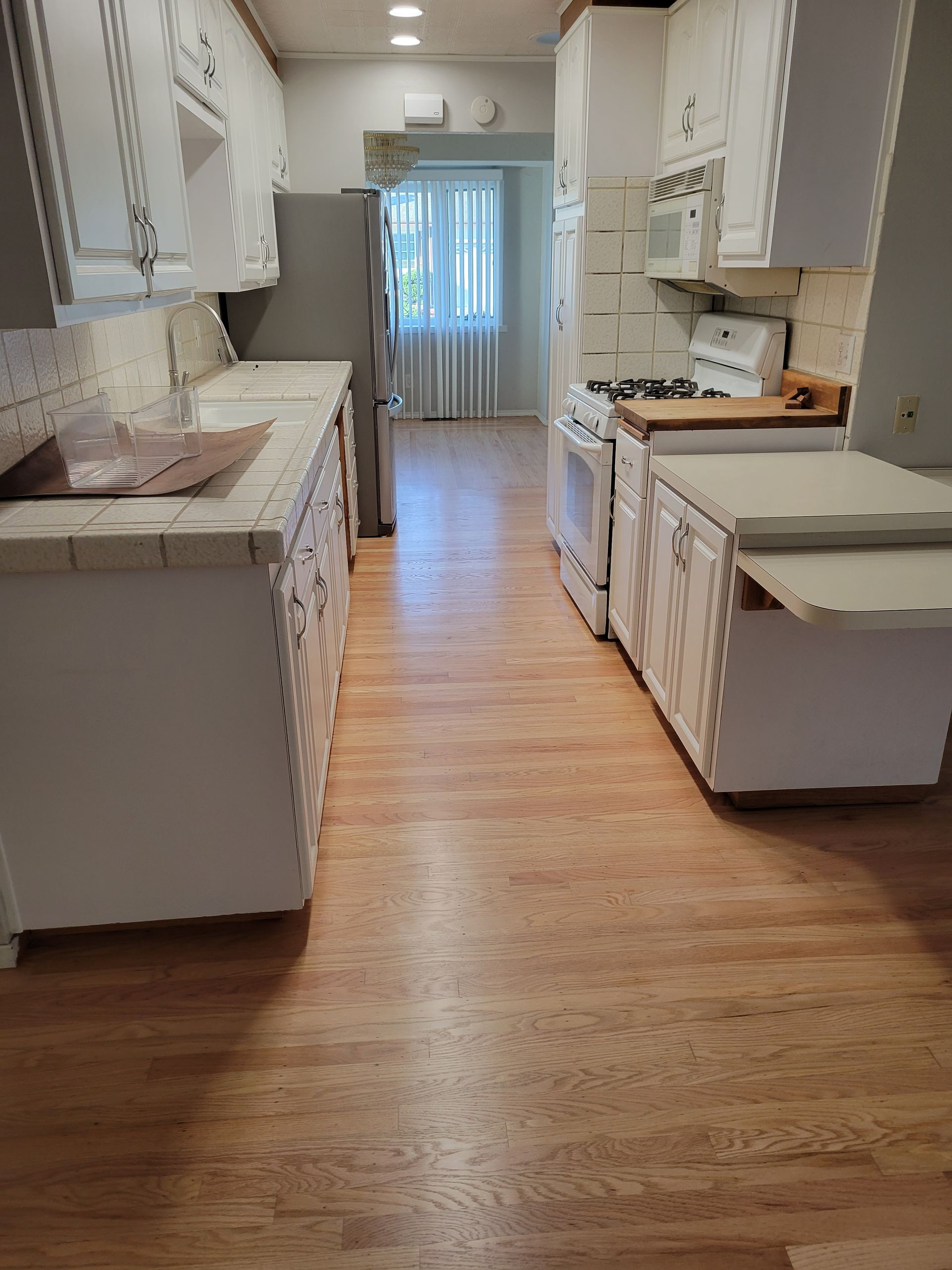 Hardwood floor with wooden railing. Beige walls. Room is empty.