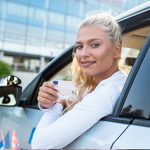 Off-Site Road Test — Woman Showing Her Driver License in Riverside, CT