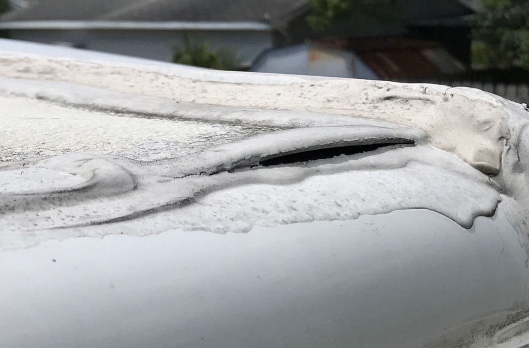 A white truck is parked in a parking lot next to a building.