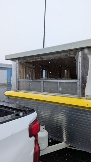 A white truck is parked in a parking lot next to a building.