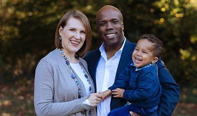 A man and woman are posing for a picture with a child.