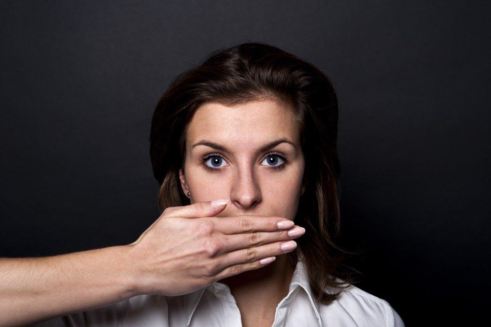 female covering her mouth with a secret