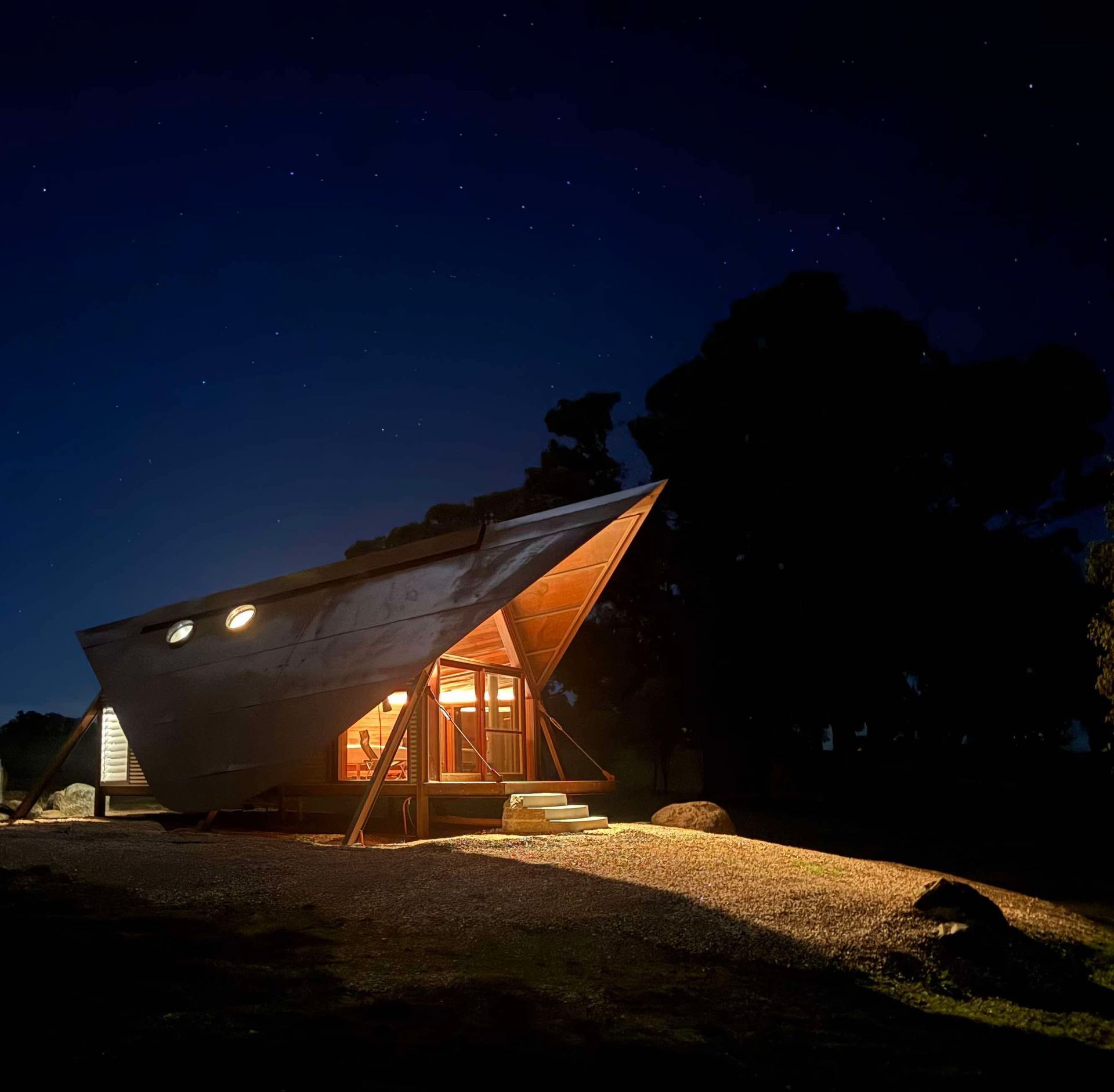 Wooden cabin illuminated at night, under a starry sky— SJD Electrical Contracting in Orange, NSW