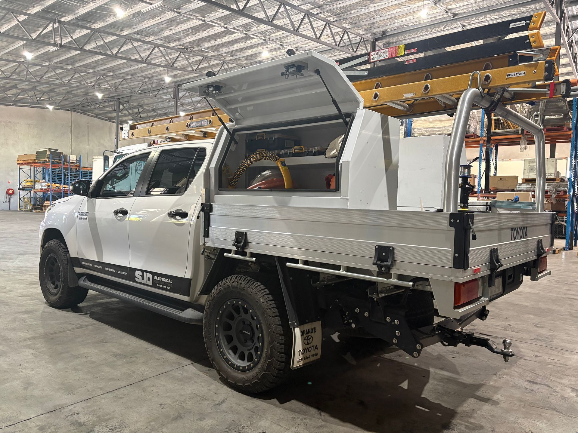 White pickup truck with a utility bed, canopy open, parked inside a warehouse— SJD Electrical Contracting in Orange, NSW