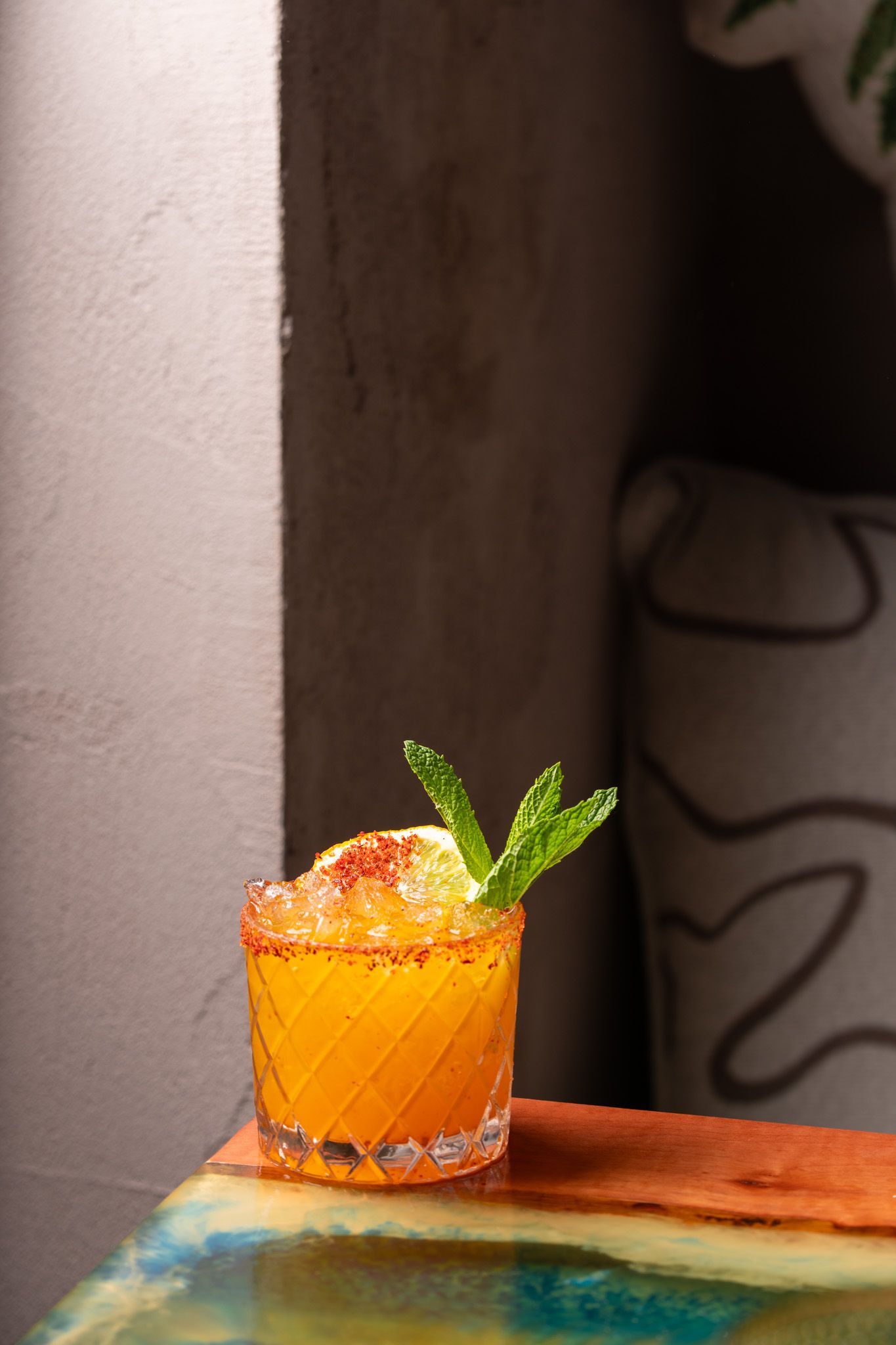 Bright orange cocktail in the corner of Brisa Restaurant & Bar. 