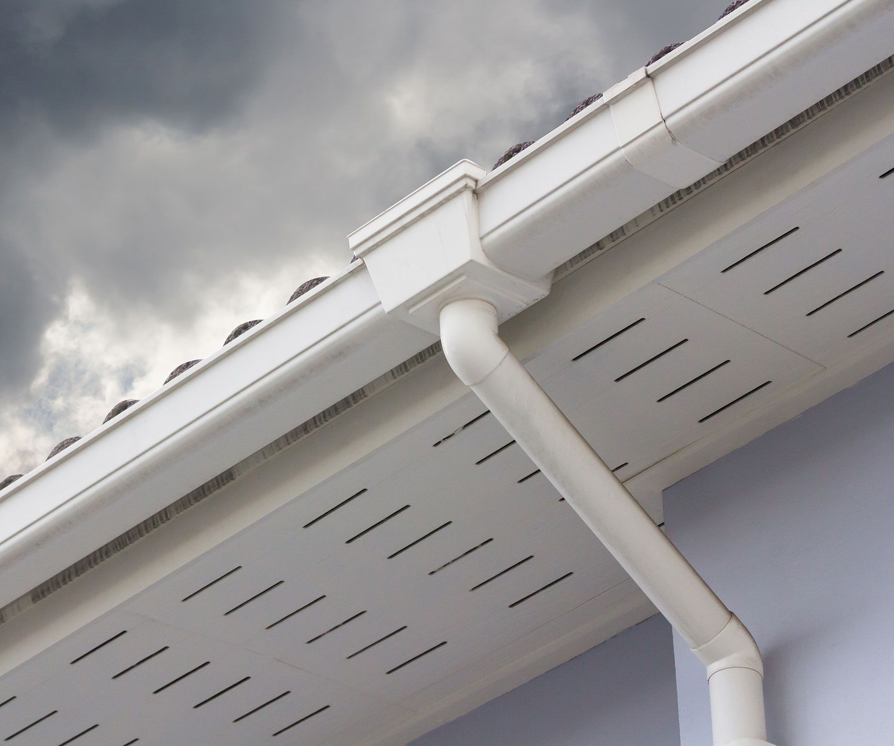 white plastic rain gutter and dark sky