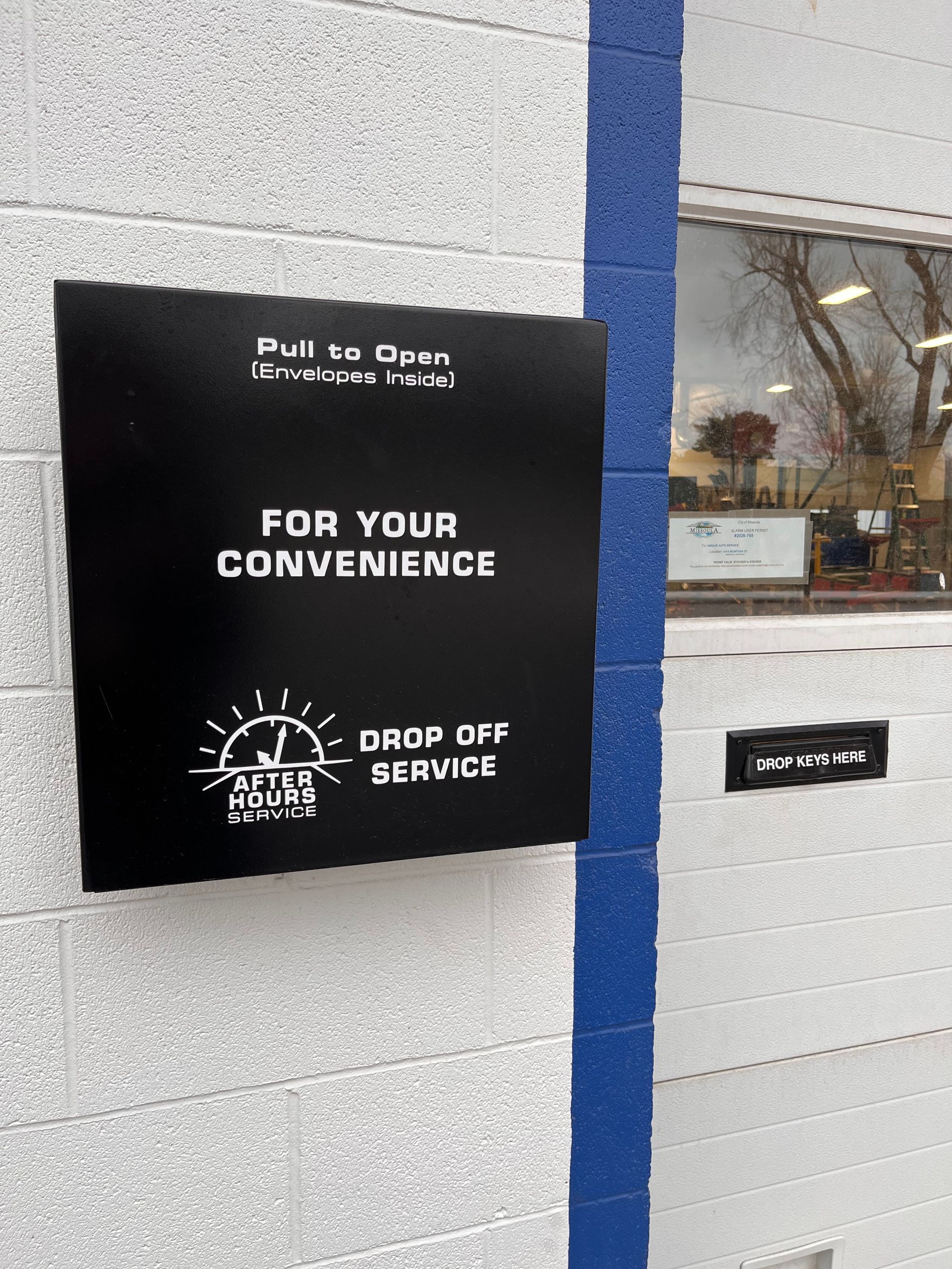 White mailbox on wall, sign says 