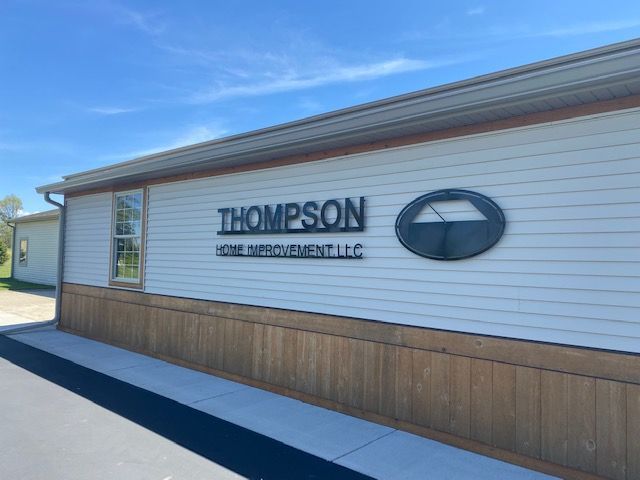 The side of a building featuring a black sign that reads 