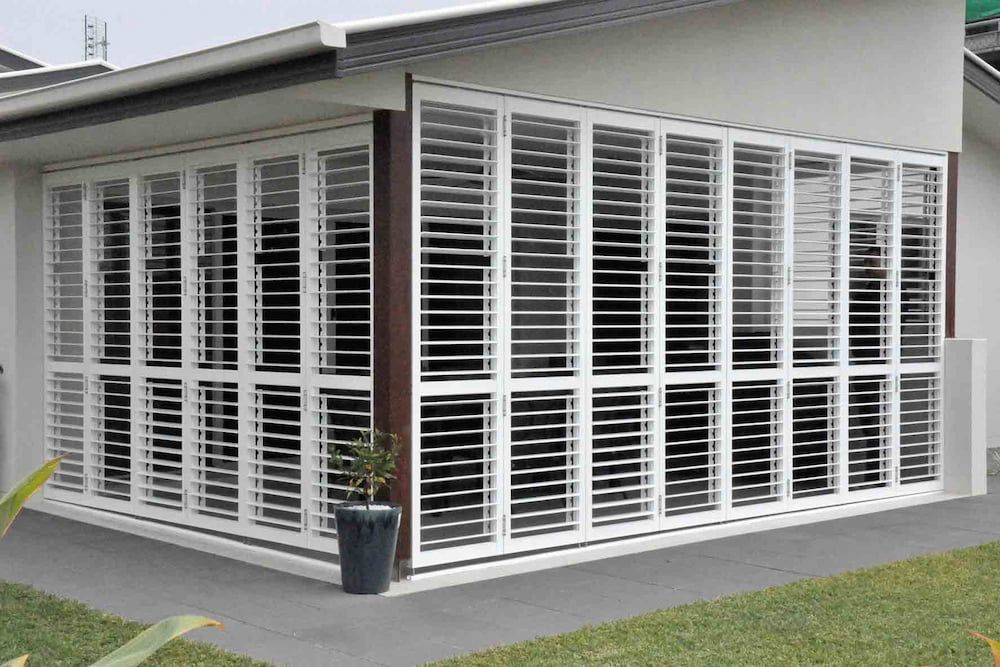 A House With A Lot Of Windows And Shutters On It — Balcony Shutters Australia In Moffat Beach, QLD