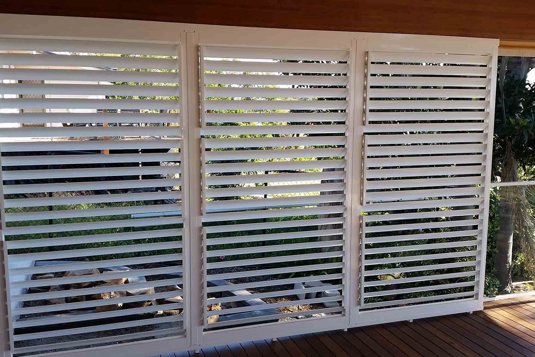 A Balcony With White Shutters On It And A Wooden Deck — Balcony Shutters Australia In Sunshine Coast, QLD