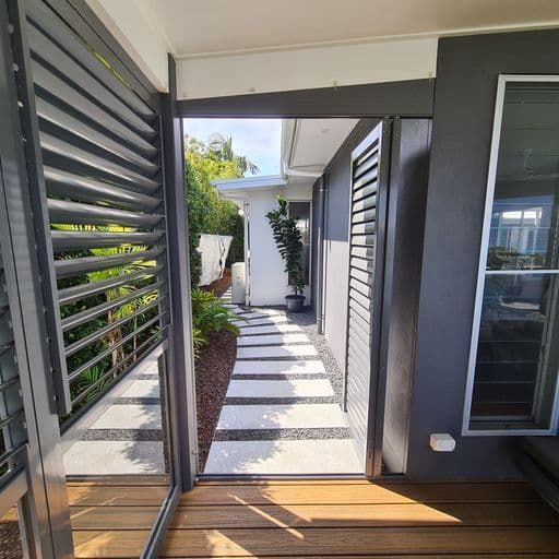 A Walkway Leading To A House With Shutters On The Windows — Balcony Shutters Australia In Moffat Beach, QLD