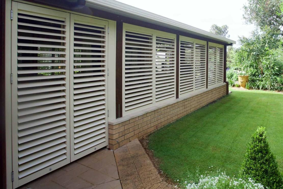 A House With A Lot Of Shutters On The Side Of It — Balcony Shutters Australia In Moffat Beach, QLD