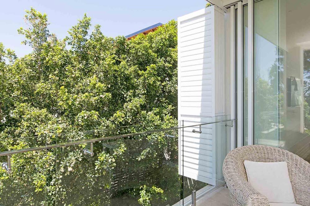 A Balcony With A Chair And A Tree — Balcony Shutters Australia In Moffat Beach, QLD