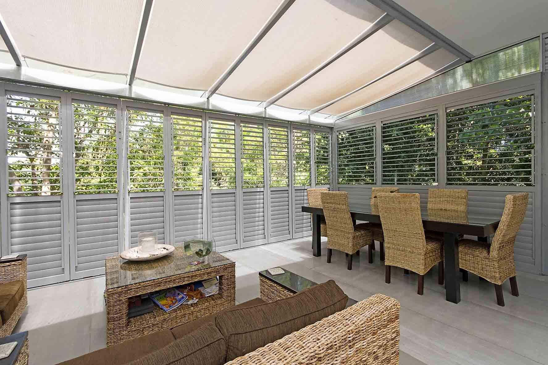 A Living Room With A Couch, Table And Chairs — Balcony Shutters Australia In Moffat Beach, QLD