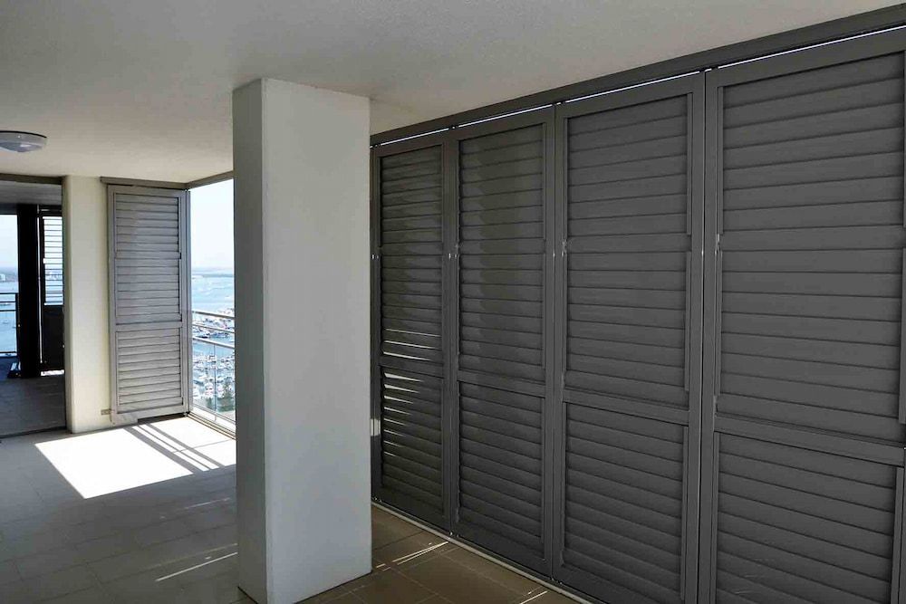 A Room With A Lot Of Shutters On The Wall — Balcony Shutters Australia In Moffat Beach, QLD